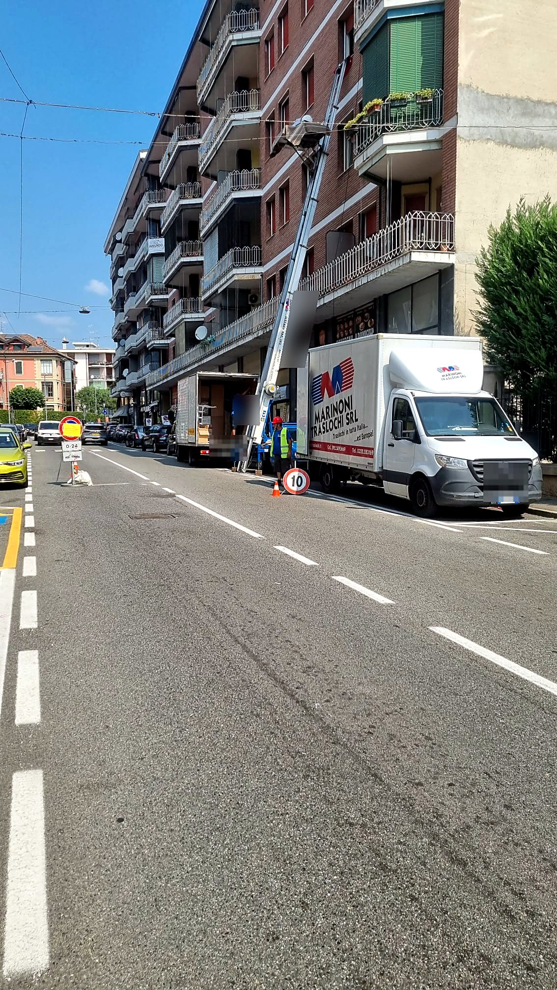 Lavoro reale: autoscala a guida Marinoni al quarto piano di un palazzo, con autocarro e operatore