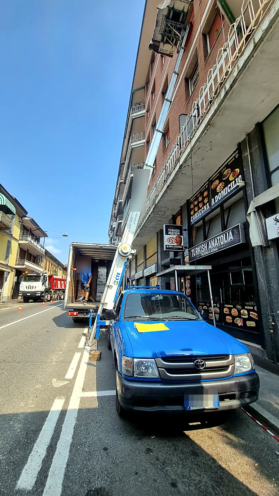Lavoro reale: autoscala Marinoni estesa su un palazzo alto, operatore al carico