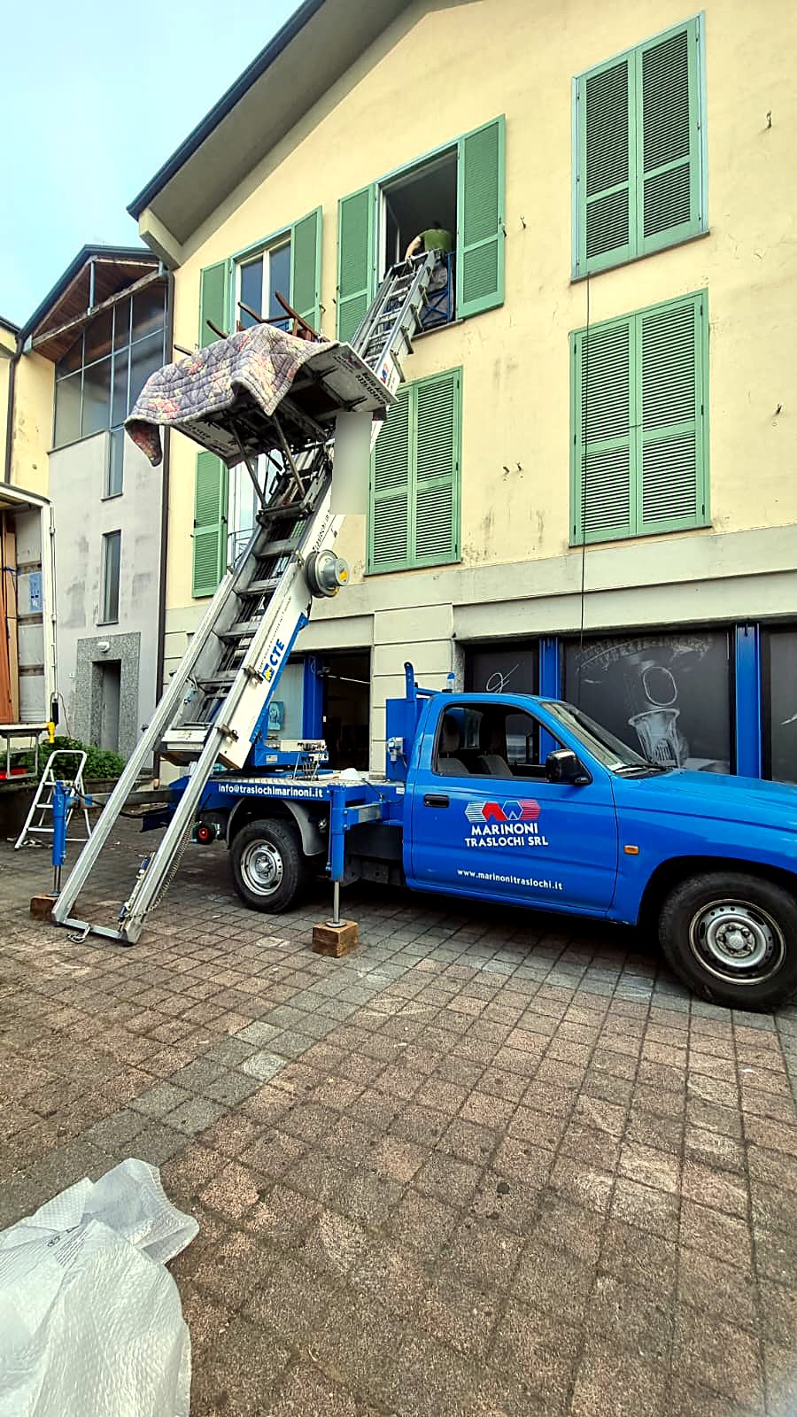 Lavoro reale: mobili protetti da coperte sulla piattaforma dell'autoscala Marinoni